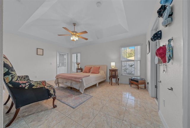 bedroom with a raised ceiling and ceiling fan