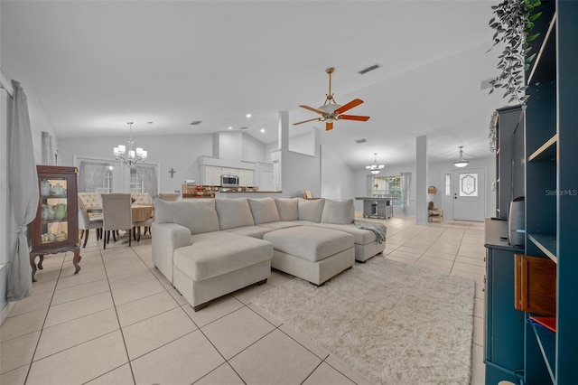 living room with lofted ceiling, light tile patterned floors, and ceiling fan with notable chandelier