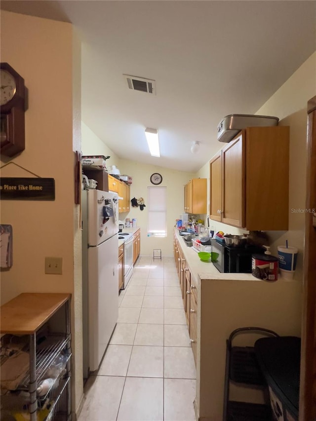 kitchen featuring light tile patterned floors, white appliances, and vaulted ceiling