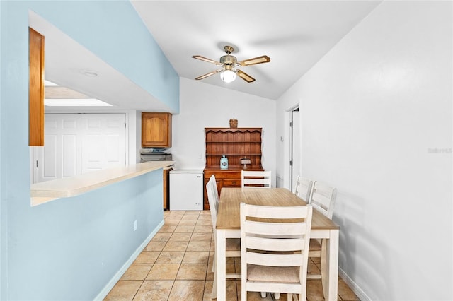 dining room featuring ceiling fan, light tile patterned floors, and lofted ceiling