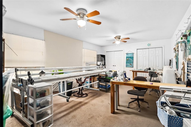 carpeted home office featuring ceiling fan and a workshop area