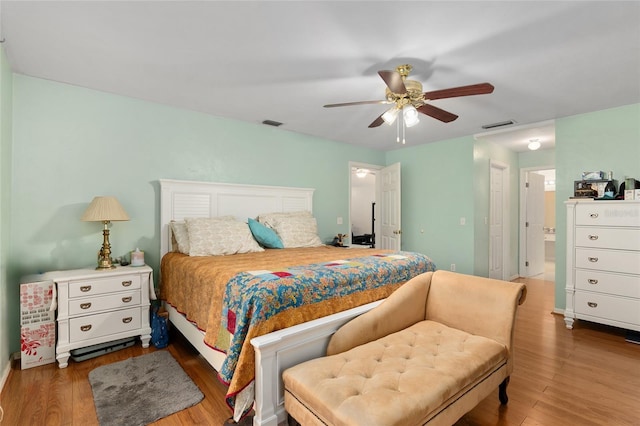 bedroom with ceiling fan, dark hardwood / wood-style flooring, and ensuite bath