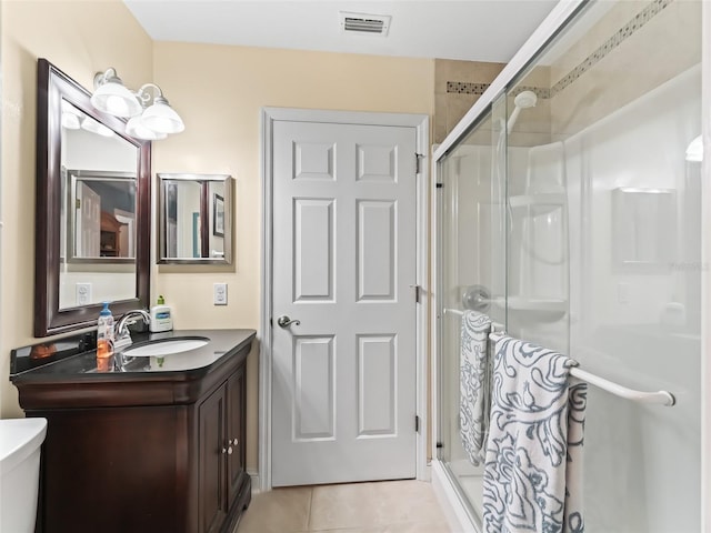 bathroom featuring walk in shower, tile patterned floors, toilet, and vanity