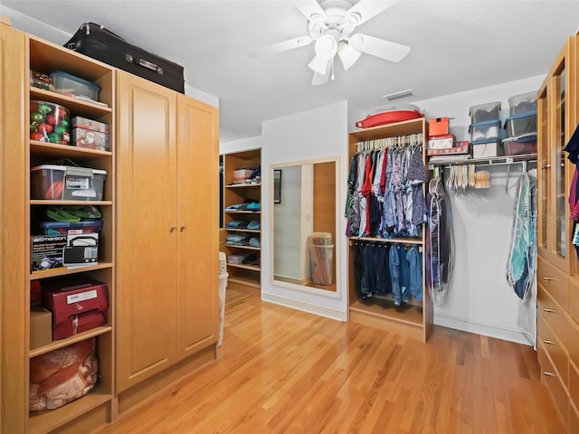 spacious closet featuring light hardwood / wood-style flooring and ceiling fan