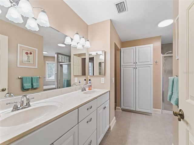 bathroom with walk in shower, vanity, and tile patterned flooring