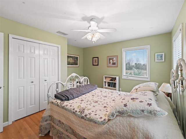 bedroom with a closet, ceiling fan, and light wood-type flooring