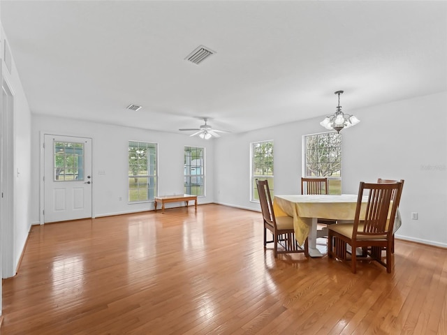 dining space featuring ceiling fan with notable chandelier, light hardwood / wood-style flooring, and a wealth of natural light