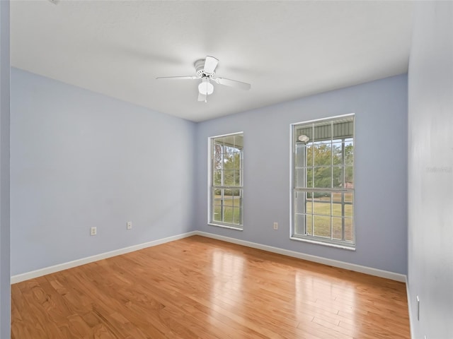 empty room with ceiling fan and light hardwood / wood-style flooring