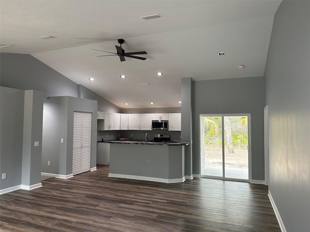 kitchen with ceiling fan, high vaulted ceiling, stainless steel appliances, white cabinets, and dark hardwood / wood-style flooring