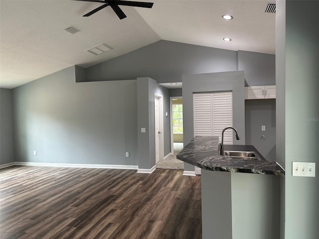 kitchen featuring vaulted ceiling, sink, white cabinets, ceiling fan, and dark wood-type flooring