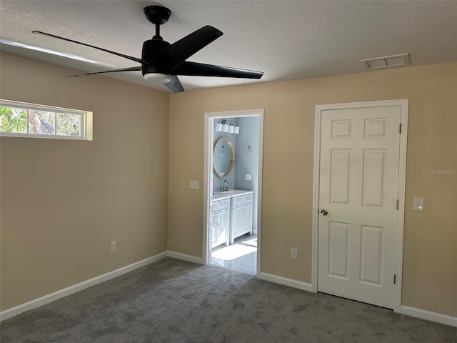 spare room with sink, ceiling fan, a textured ceiling, and carpet