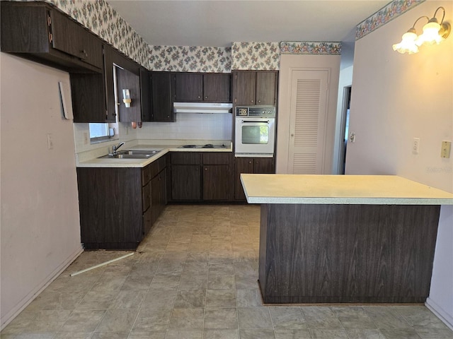 kitchen with dark brown cabinetry, sink, white appliances, and decorative backsplash