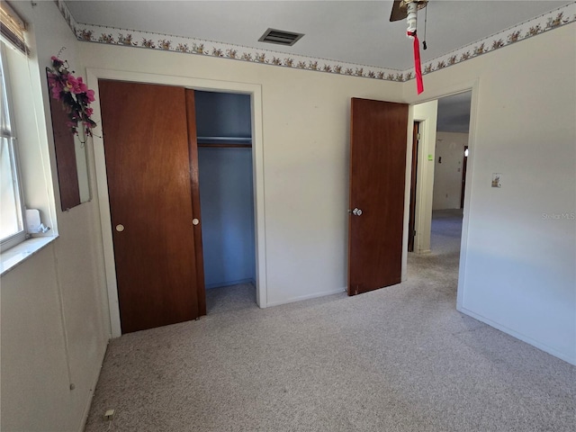 unfurnished bedroom featuring carpet, ceiling fan, and a closet