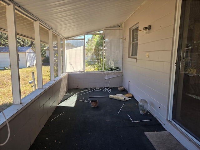 unfurnished sunroom featuring vaulted ceiling