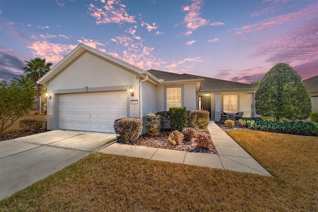 ranch-style house with a garage and a lawn