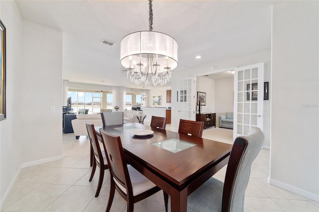 tiled dining space featuring a notable chandelier