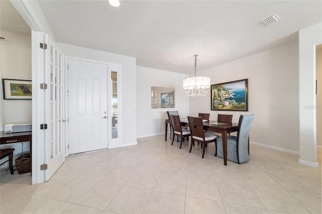 dining area with light tile patterned floors and a notable chandelier