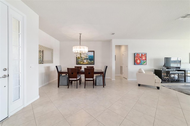 dining room featuring a healthy amount of sunlight, a chandelier, a textured ceiling, and light tile patterned floors