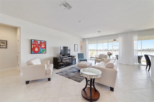 tiled living room with plenty of natural light and a textured ceiling