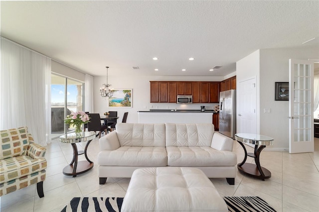 living room featuring an inviting chandelier, light tile patterned floors, and a textured ceiling