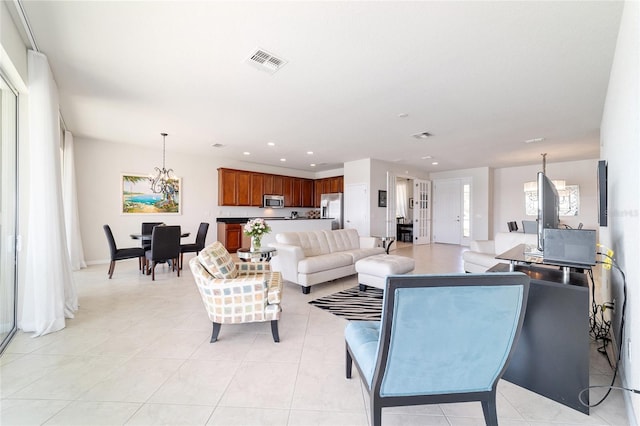 living room with light tile patterned floors and a notable chandelier