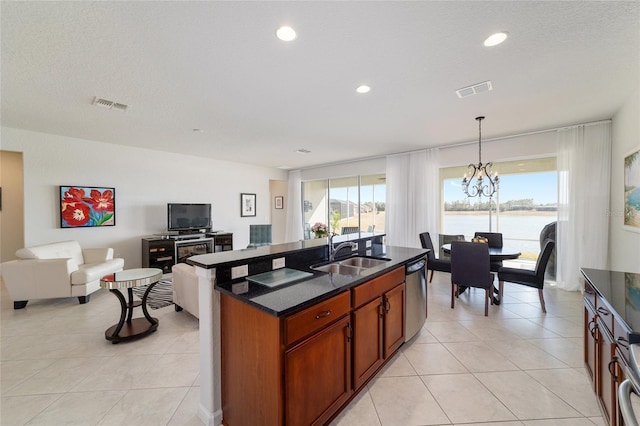 kitchen featuring sink, light tile patterned floors, an inviting chandelier, hanging light fixtures, and stainless steel dishwasher