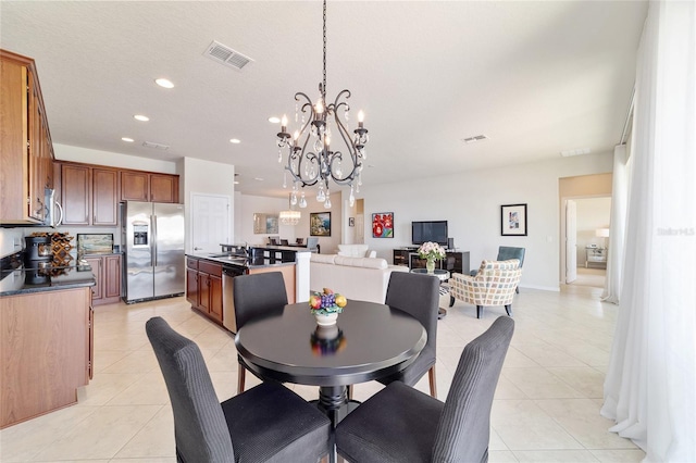 tiled dining space with sink and a notable chandelier