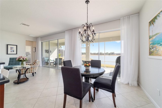 dining area featuring a water view, light tile patterned flooring, and a wealth of natural light