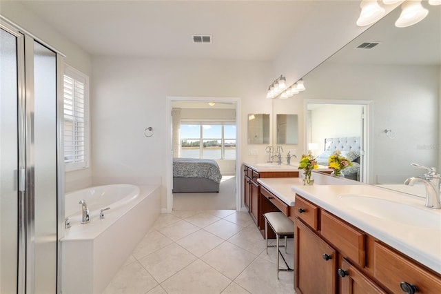 bathroom featuring vanity, a bath, plenty of natural light, and tile patterned floors