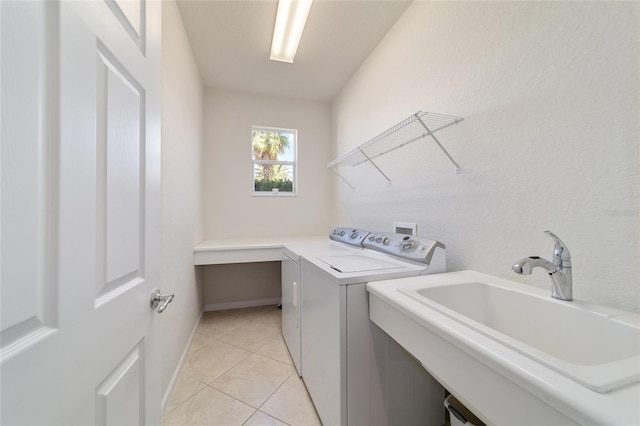 laundry area featuring sink, light tile patterned floors, and washer and clothes dryer