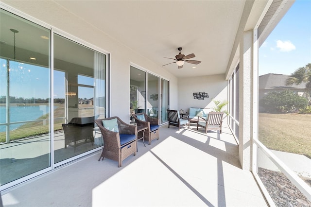 sunroom with a water view and ceiling fan