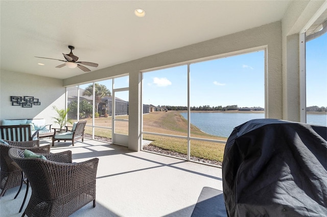 sunroom featuring a water view, a wealth of natural light, and ceiling fan