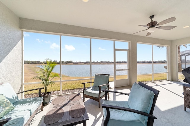 sunroom featuring a water view and ceiling fan