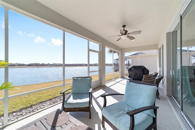 sunroom / solarium with ceiling fan and a water view