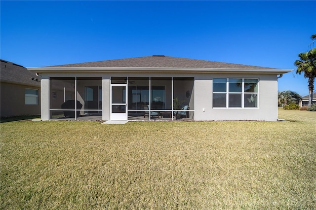 rear view of property featuring a yard and a sunroom