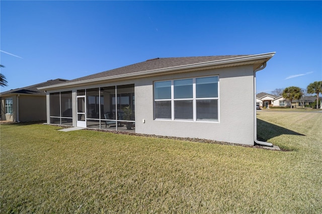 rear view of house featuring a sunroom and a yard