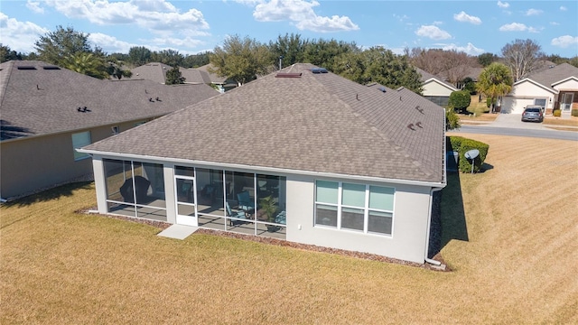 rear view of property featuring a sunroom and a lawn