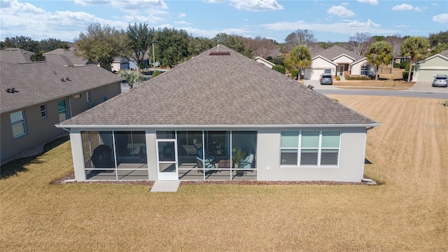 rear view of property with a yard and a sunroom