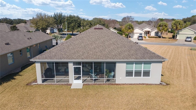 back of house with a yard and a sunroom