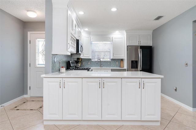 kitchen with tasteful backsplash, a healthy amount of sunlight, stainless steel appliances, and white cabinets