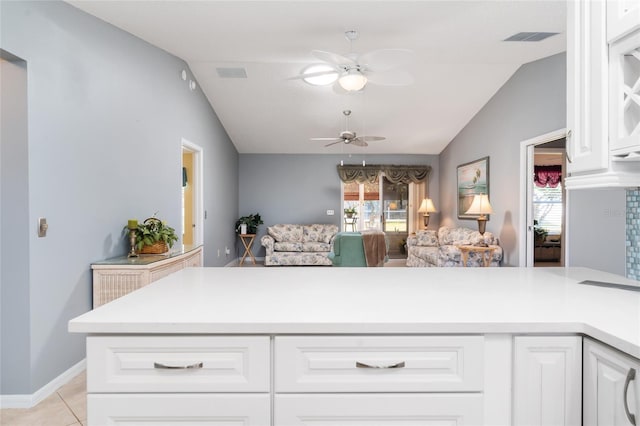 kitchen with white cabinetry, light tile patterned floors, vaulted ceiling, and ceiling fan