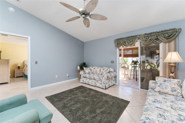 living room featuring ceiling fan, lofted ceiling, and light tile patterned floors