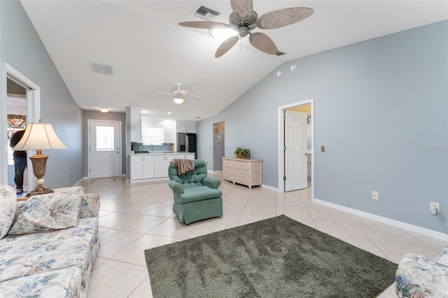 tiled living room featuring lofted ceiling, ceiling fan, and a textured ceiling