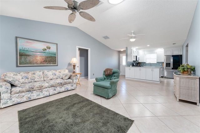 tiled living room with lofted ceiling, sink, and ceiling fan