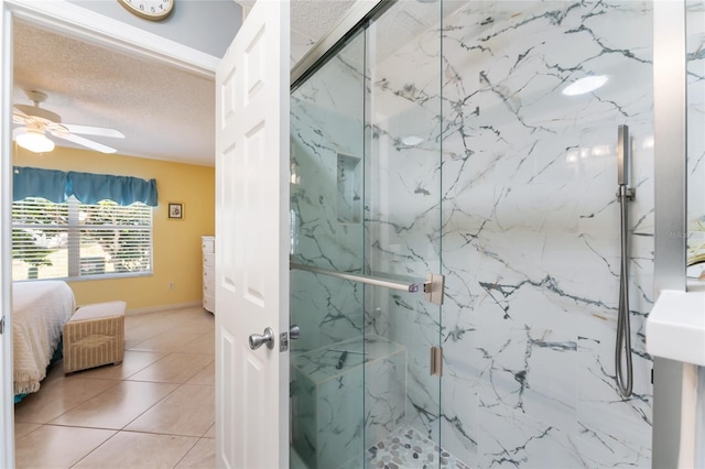 bathroom featuring ceiling fan, tile patterned floors, a shower with shower door, and a textured ceiling