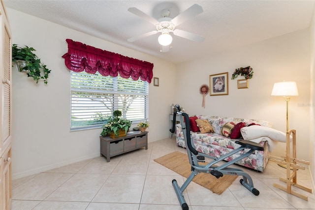 interior space with light tile patterned floors, a textured ceiling, and ceiling fan