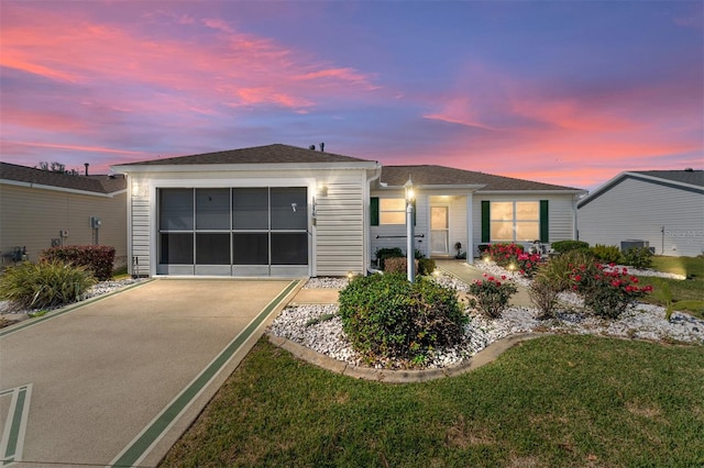 ranch-style home with a garage and a yard