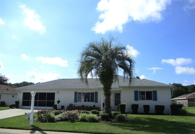 ranch-style house with a garage, concrete driveway, and a front lawn