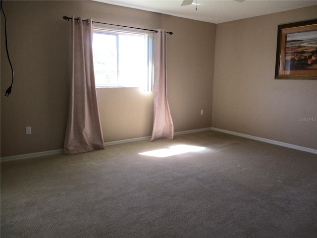 spare room with carpet floors, ceiling fan, and baseboards