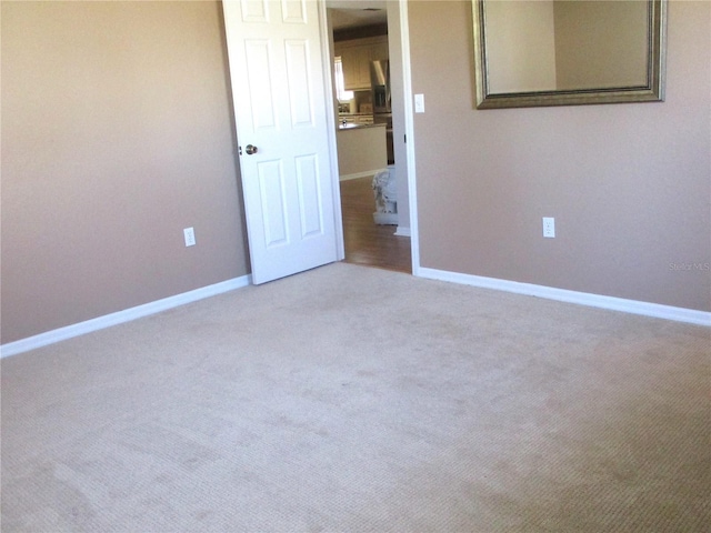 carpeted empty room with baseboards